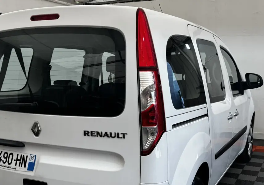 Vue 3/4 arrière droite d'un Renault Kangoo blanc 2016 avec feux arrière verticaux et vitres teintées.