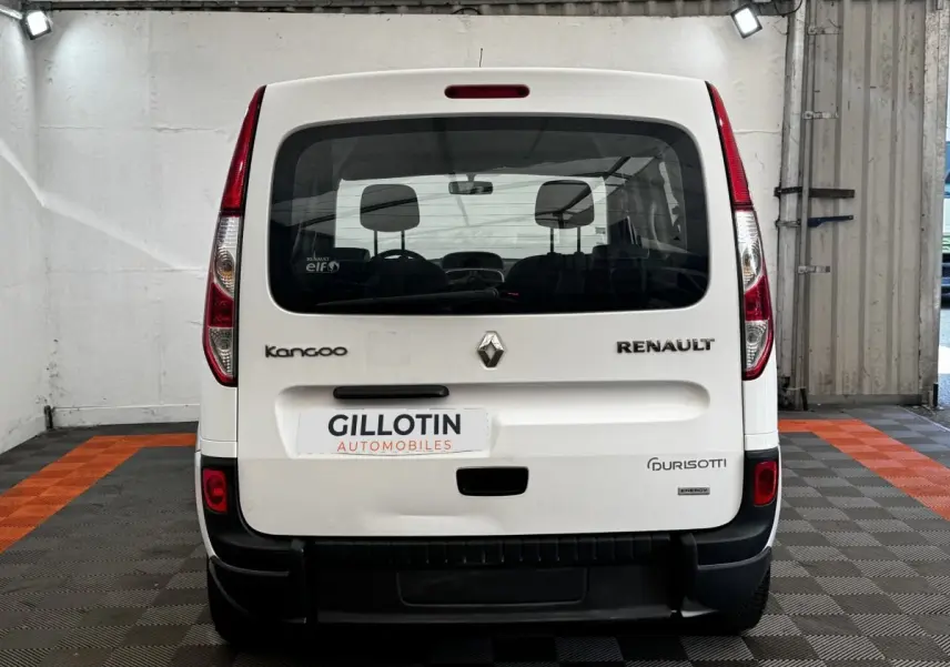 Vue arrière d’un Renault Kangoo blanc 2016 avec logos visibles et plaque d’un concessionnaire en intérieur.