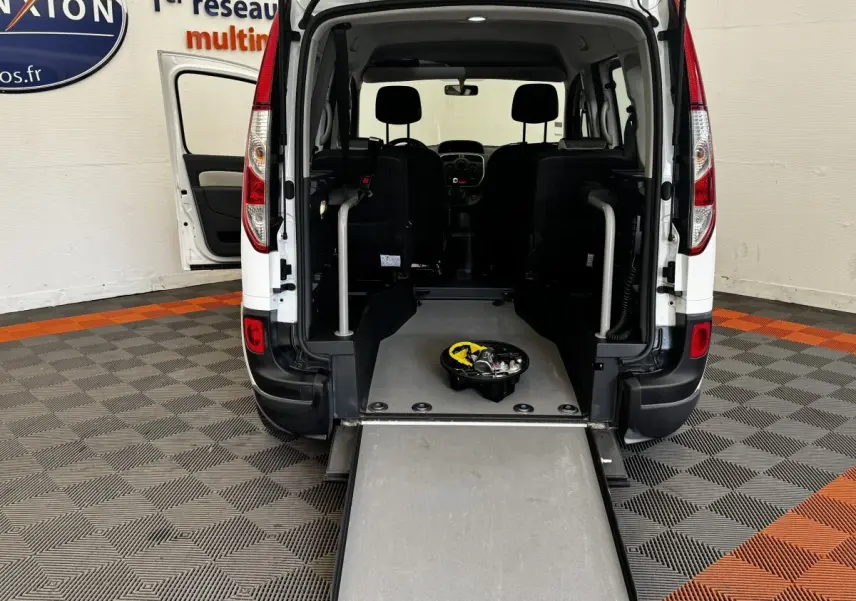 Vue arrière du Renault Kangoo blanc 2016 avec porte ouverte et rampe d'accès déployée, intérieur visible.