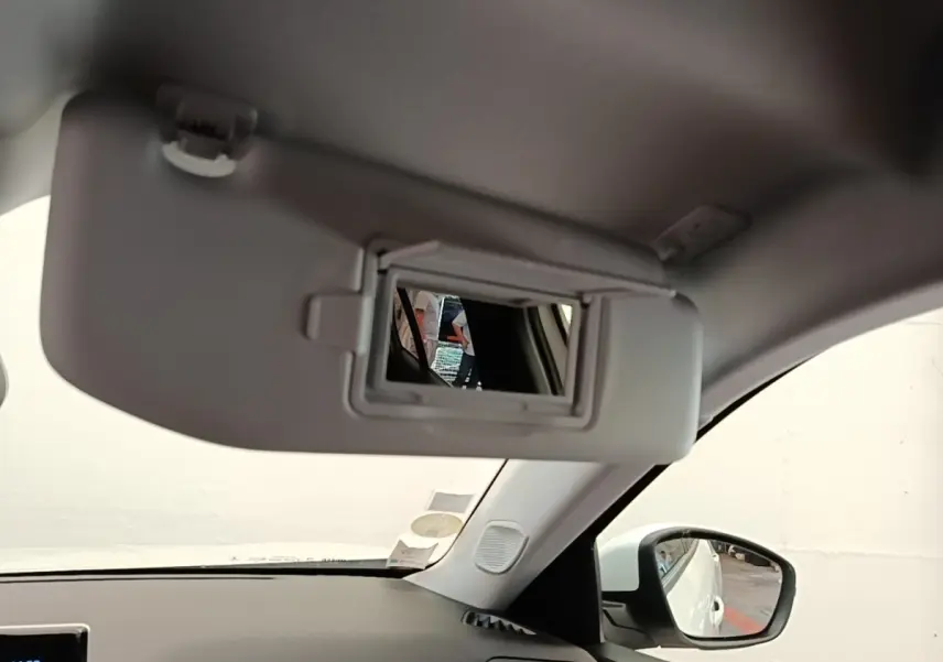 Intérieur du Peugeot 2008 blanc, vue côté droit sur le pare-soleil avec miroir de courtoisie ouvert.