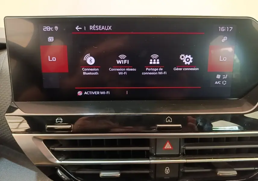 Gros plan sur l’écran tactile central du tableau de bord de la Citroën C4 gris clair, affichant les options Wi-Fi et Bluetooth.