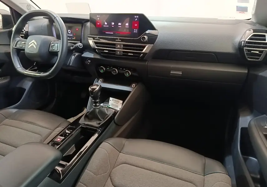 Intérieur de Citroën C4 gris clair, vue côté conducteur, volant cuir multifonctions et écran tactile central.