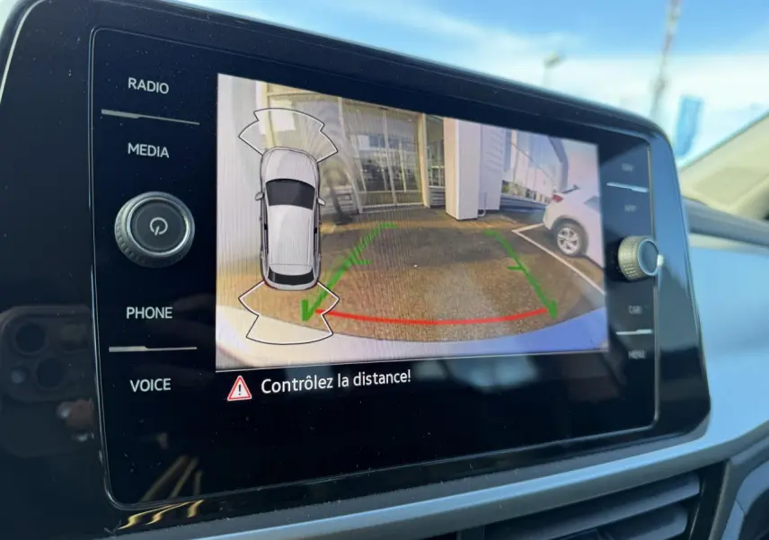 Écran tactile intérieur du Volkswagen T-Roc gris Pyrite montrant la caméra de recul avec guidage de trajectoire.