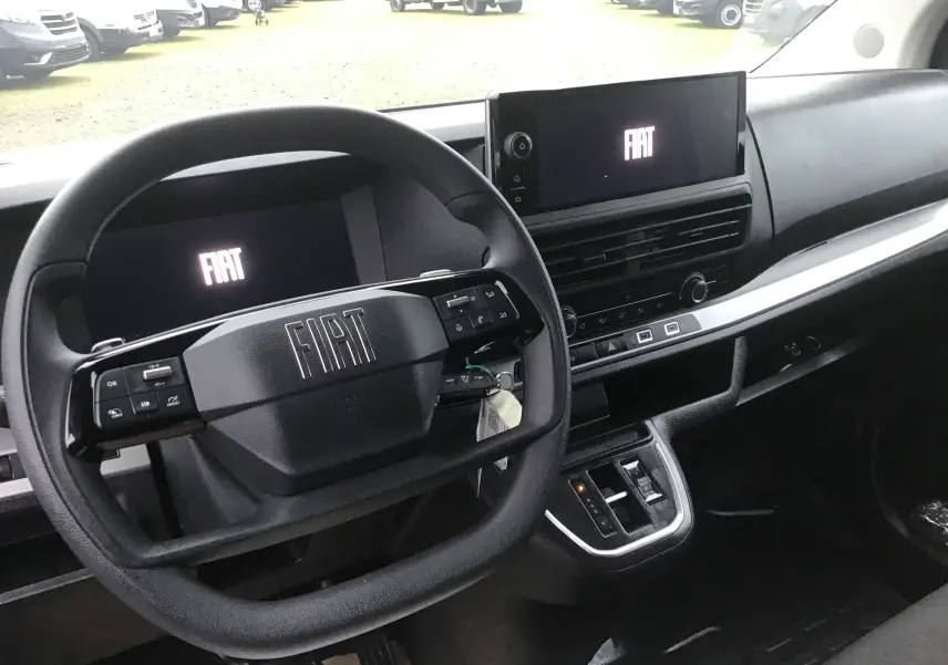 Vue intérieure du tableau de bord et volant noir du Fiat Scudo Fourgon 2024 avec écran central et commandes intégrées.