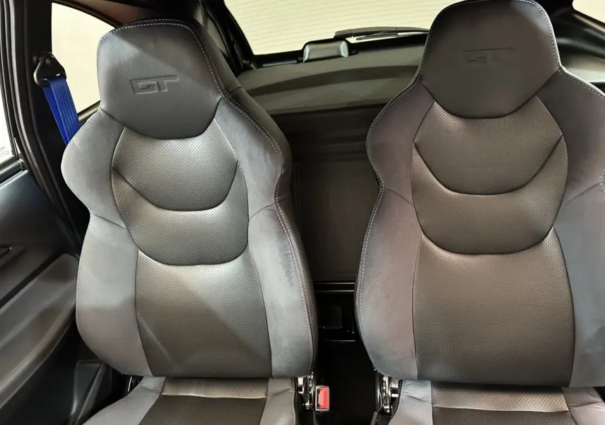 Gros plan sur les sièges avant noirs GT de l'AIXAM AMBITION 0.5 CITY COUPE GTI E5+ 2026, vue intérieure.