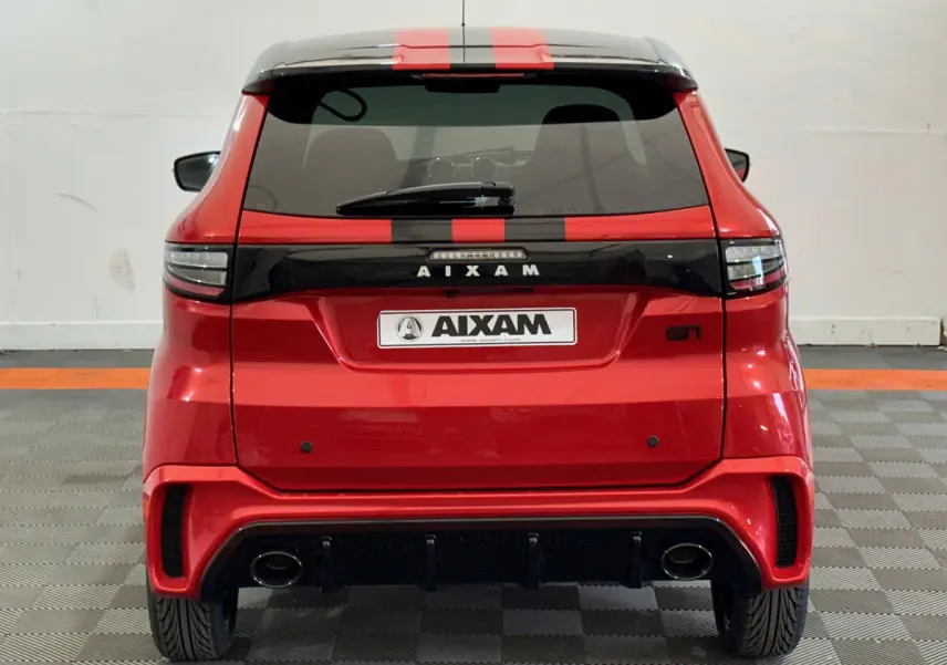 Vue arrière d'une AIXAM Ambition rouge 2026 avec bandes noires et double sortie d'échappement visible.