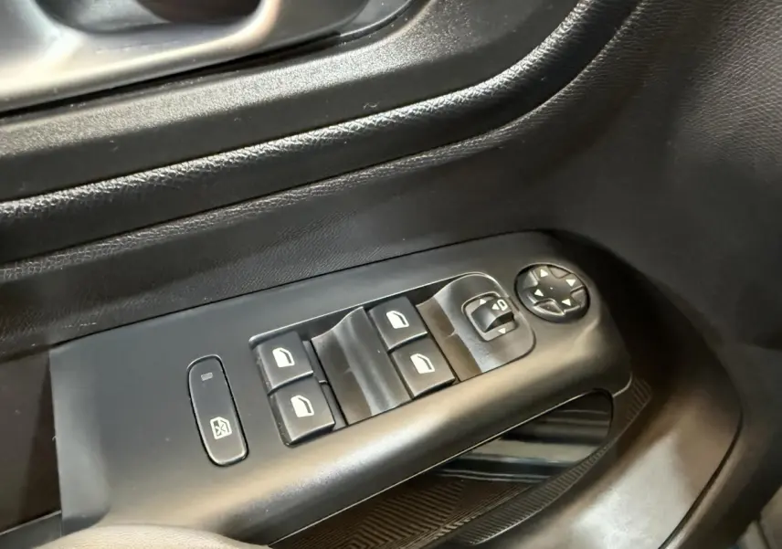 Gros plan sur les commandes de lève-vitres et rétroviseurs électriques côté conducteur d’un Citroën C5 Aircross Hybrid bleu.