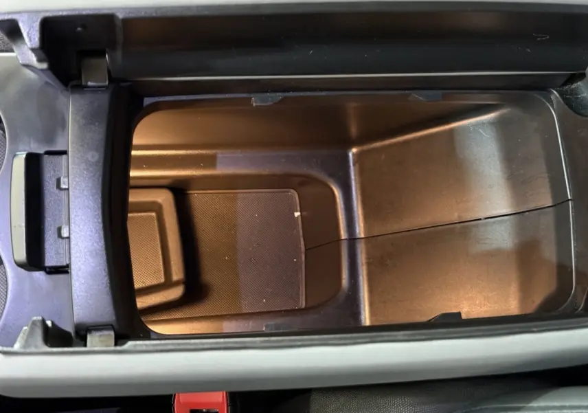 Vue plongeante sur le rangement central intérieur du Citroën C5 Aircross Hybrid 225 ë-EAT8 Business, plastique noir mat.