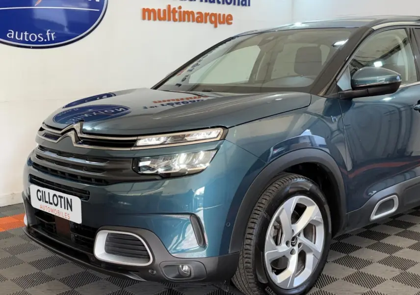 Vue 3/4 avant droit d'un Citroën C5 Aircross Hybrid bleu avec phares LED et jantes alliage distinctives.