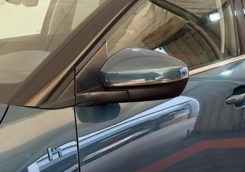 Détail du rétroviseur droit bleu métallisé du Citroën C5 Aircross Hybrid 225 ë-EAT8 Business, avec logo Hybrid visible sur la portière.