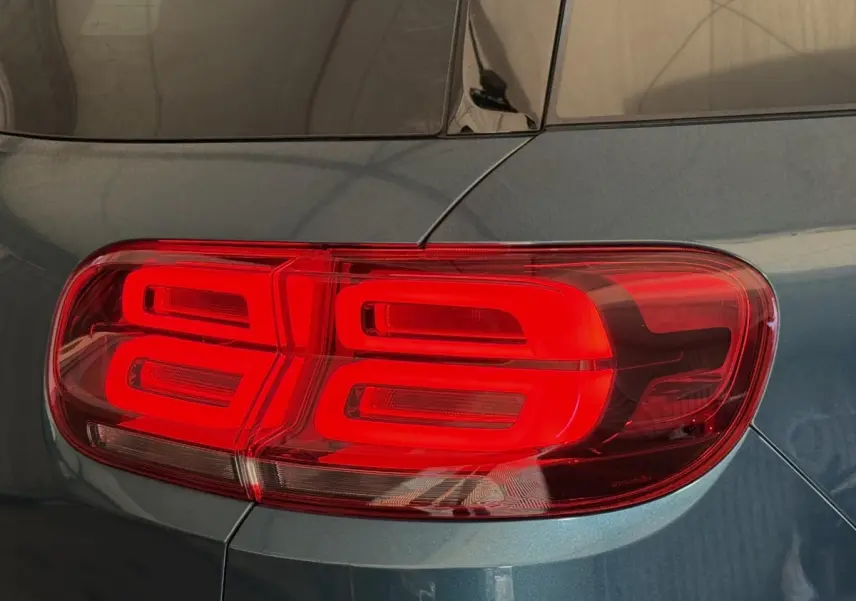 Gros plan sur le feu arrière droit rouge d’un Citroën C5 Aircross Hybrid bleu métallisé.