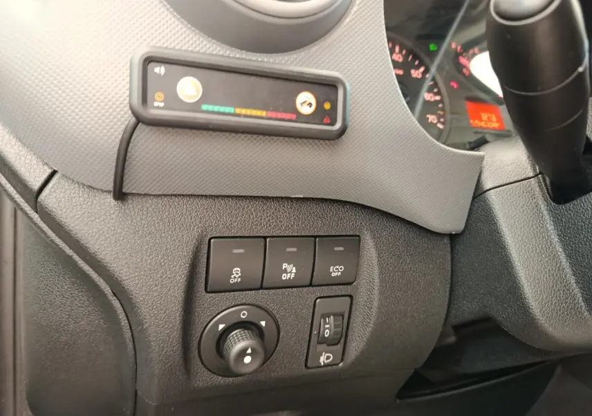 Vue rapprochée du tableau de bord côté gauche du Peugeot Partner blanc, montrant les commandes d'assistance et réglages des phares.