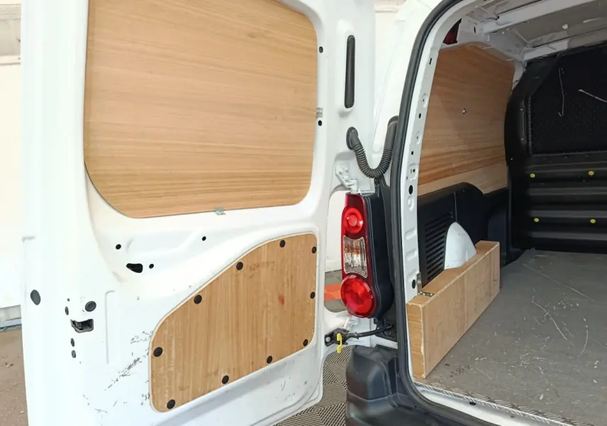 Vue arrière ouverte du Peugeot Partner blanc de 2018, montrant l'intérieur de chargement avec panneaux en bois.