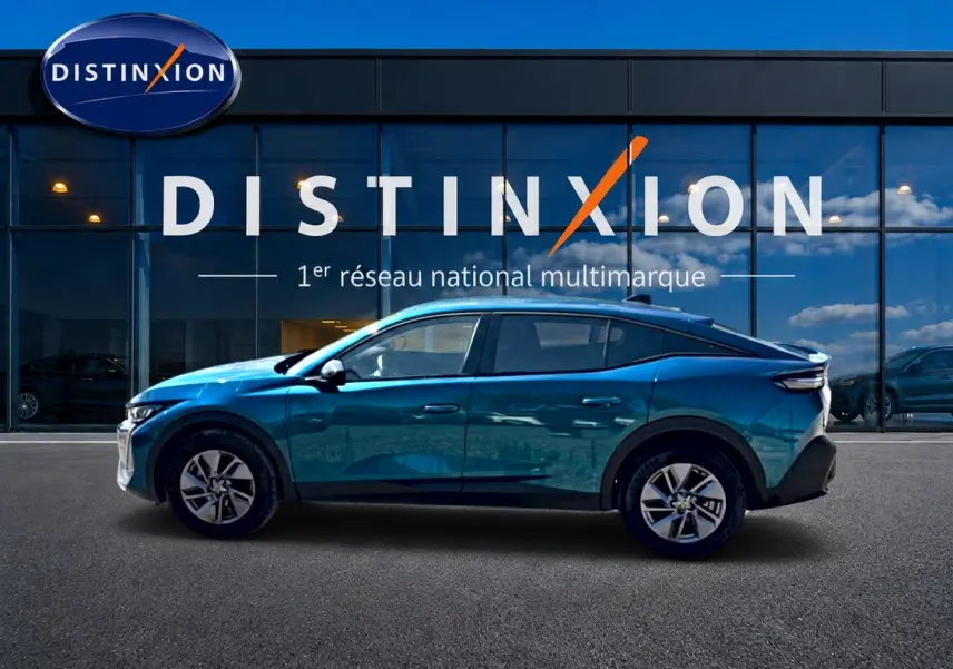 Peugeot 408 Hybrid 145 allure e-dcs6 bleu en profil droit devant une vitrine avec logo Distinxion.
