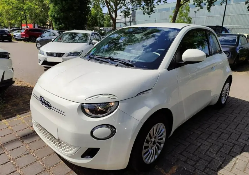 Vue 3/4 avant droite d'une FIAT 500 électrique blanche, avec phares ronds et calandre épurée.