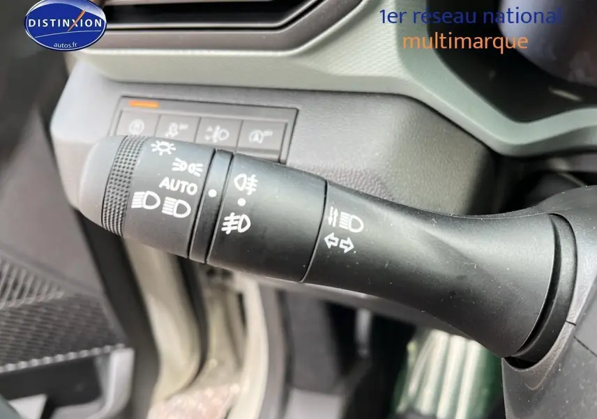 Gros plan sur la commande des phares et clignotants du Dacia Duster 2025, intérieur noir et gris.