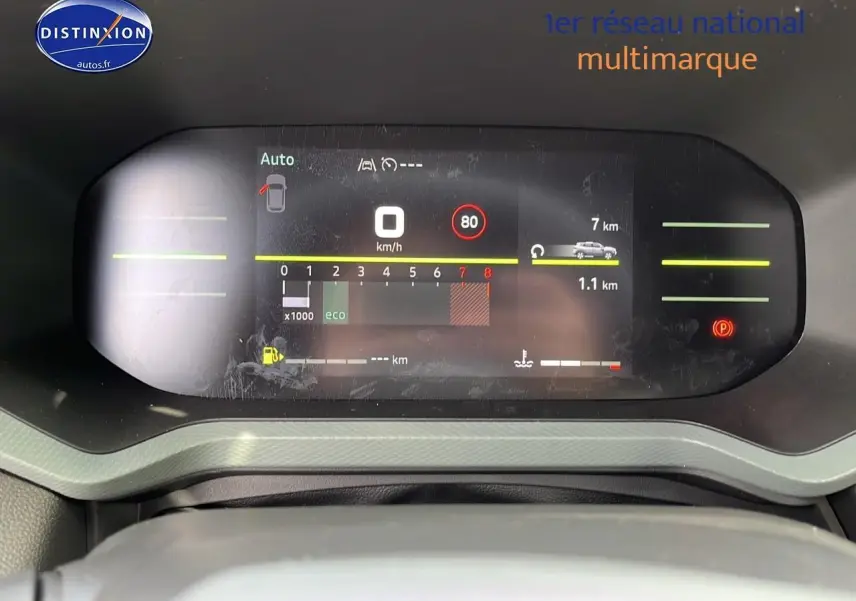 Tableau de bord numérique du Dacia Duster 2025 affichant vitesse, régime et alertes, vue frontale rapprochée.