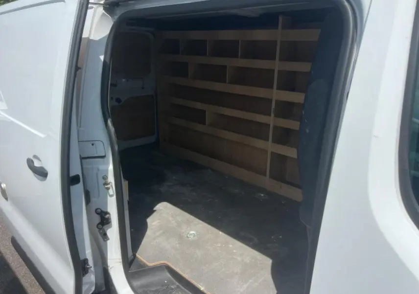 Vue latérale gauche du Citroën Jumpy blanc avec porte coulissante ouverte révélant l'espace de chargement aménagé.