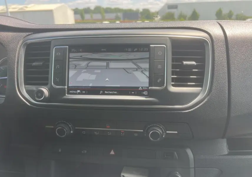 Tableau de bord du Citroën Jumpy XL blanc 2023 montrant l'écran tactile de navigation 3D et commandes de climatisation.