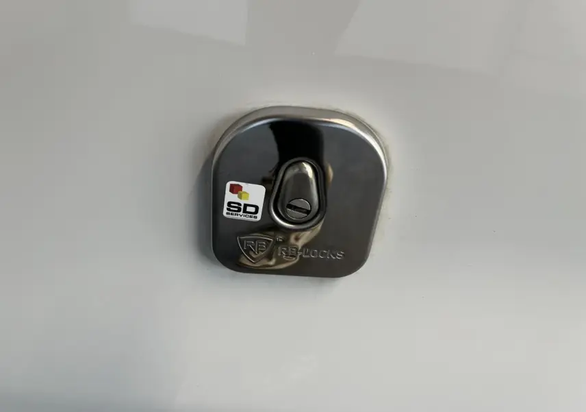 Gros plan sur la serrure de porte latérale droite en métal brillant du Citroën Jumpy XL blanc 2023.