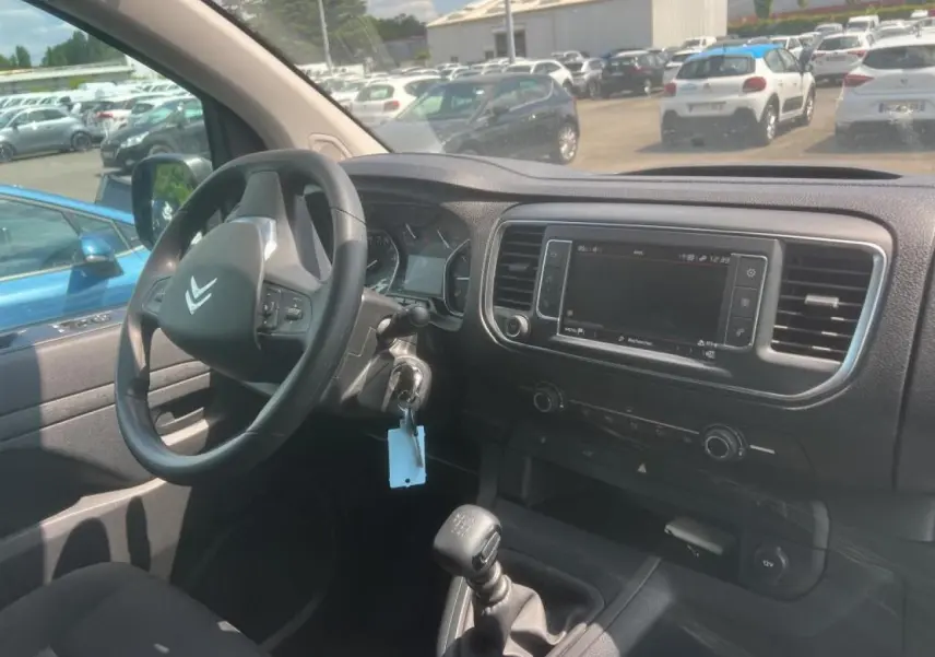 Vue intérieure côté conducteur du Citroën Jumpy blanc 2023, montrant volant, tableau de bord et écran tactile central.
