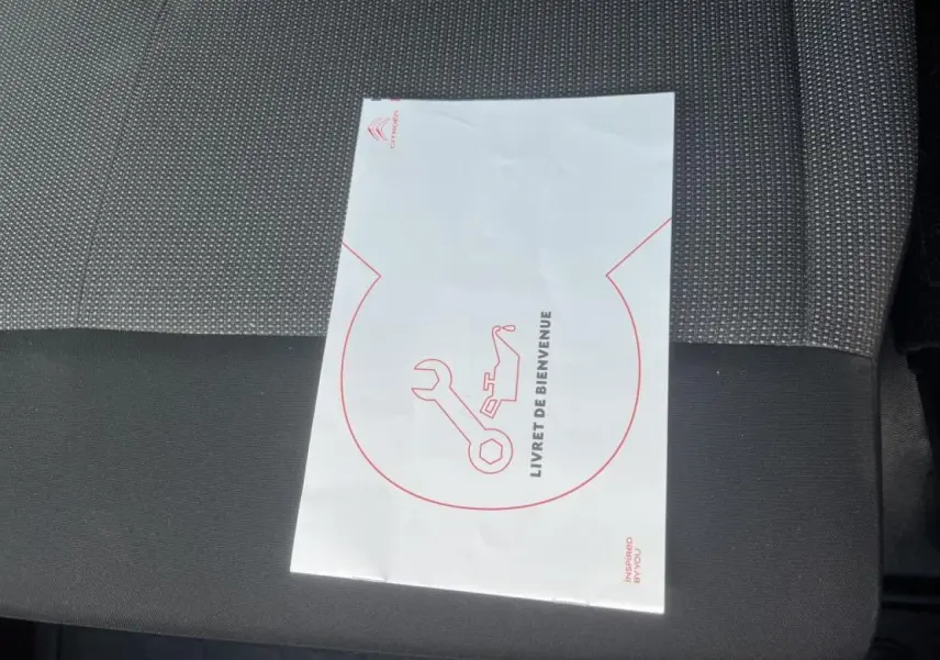 Livret de bienvenue Citroën posé sur siège tissu bi-ton noir et gris du Citroën Jumpy XL blanc 2023.