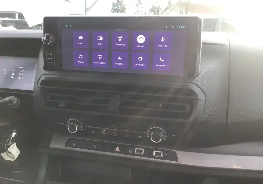Vue intérieure du tableau de bord du Fiat Scudo Fourgon 2024, avec écran tactile central et commandes climatisation visibles.
