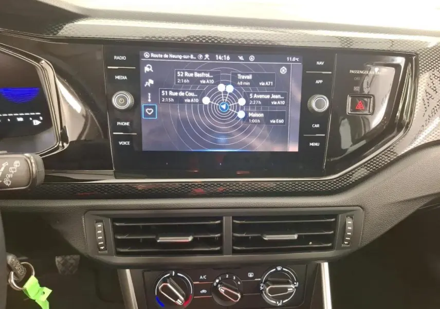 Vue rapprochée du tableau de bord de la Volkswagen Polo 2023 avec écran tactile GPS et commandes de climatisation.