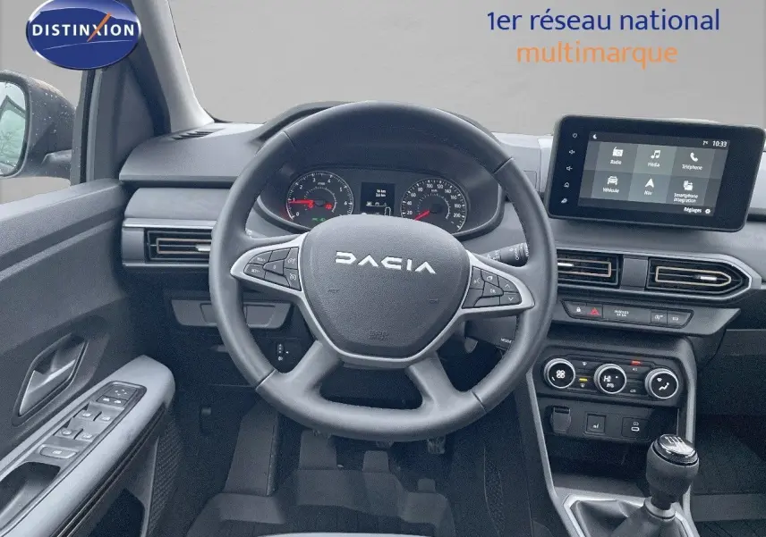 Vue intérieure du poste de conduite de la Dacia Sandero Stepway 2024, volant, tableau de bord et écran tactile visibles.