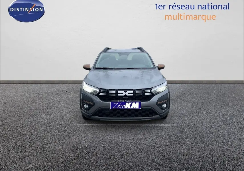 Vue frontale d'une Dacia Sandero Stepway 2024 gris schiste métal avec calandre noire et rétroviseurs bronze.