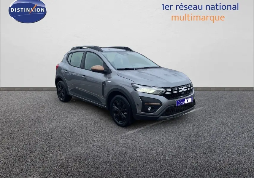Vue 3/4 avant droite d'une Dacia Sandero Stepway gris schiste métal avec rétroviseurs bronze et jantes noires.
