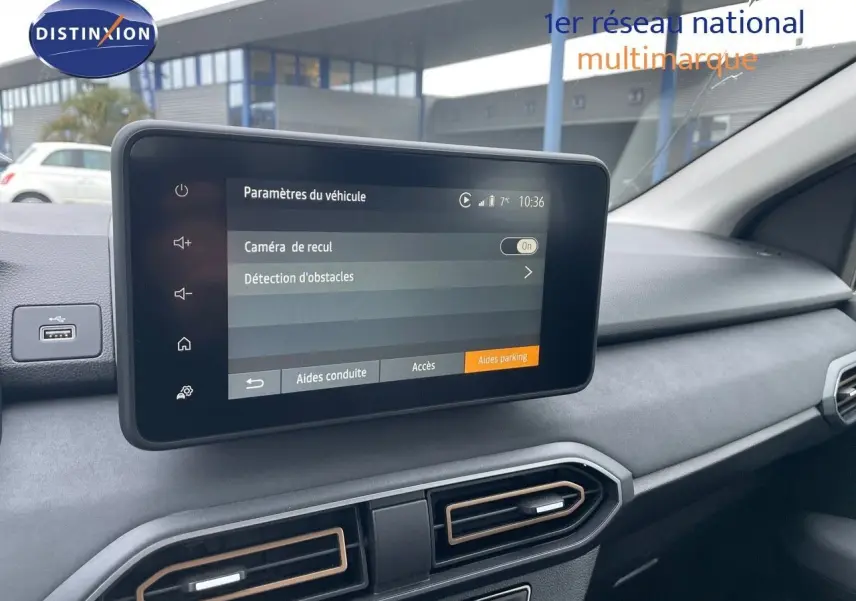 Écran tactile central affichant les paramètres de caméra de recul dans l'habitacle gris d'une Dacia Sandero Stepway 2024.