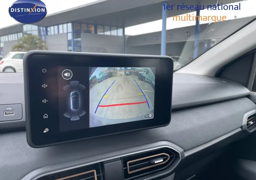 Écran tactile intérieur montrant la caméra de recul d'une Dacia Sandero Stepway gris schiste métal, tableau de bord moderne.