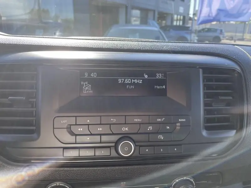 Tableau de bord du Peugeot Expert Fourgon blanc 2023, vue centrée sur l'autoradio affichant 97.60 MHz à 33°C.