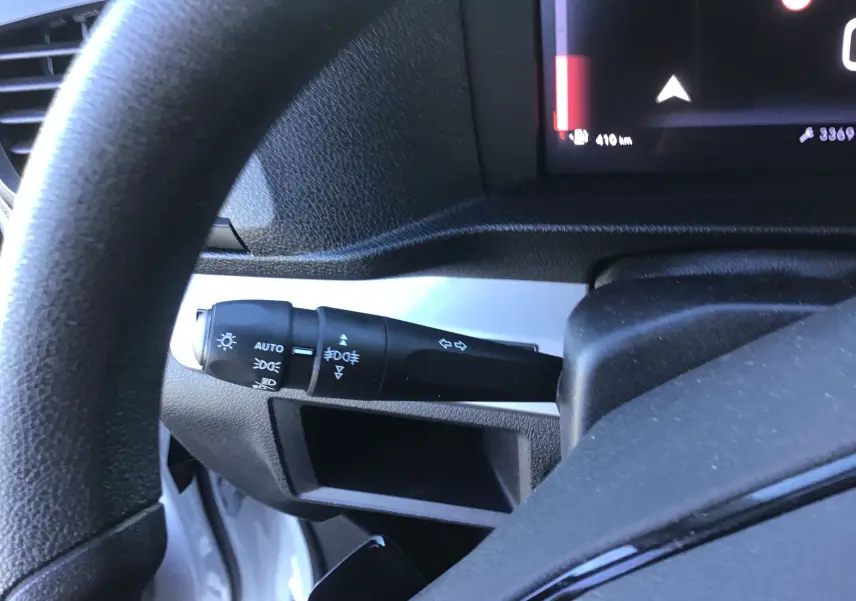 Gros plan sur la manette de clignotant à gauche du volant dans l'habitacle du FIAT Scudo Fourgon blanc 2024.