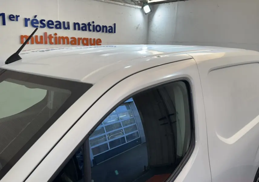 Vue de côté droit sur le haut d’un Citroën Berlingo blanc utilitaire avec antenne sur le toit et vitre avant teintée.