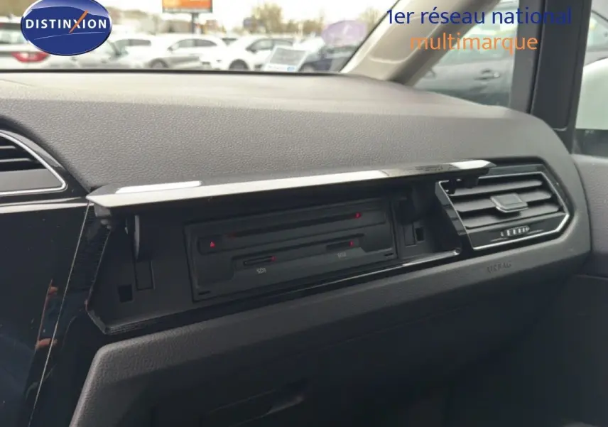 Vue intérieure du tableau de bord côté passager du Volkswagen Touran blanc de 2018, avec boîte à gants ouverte.