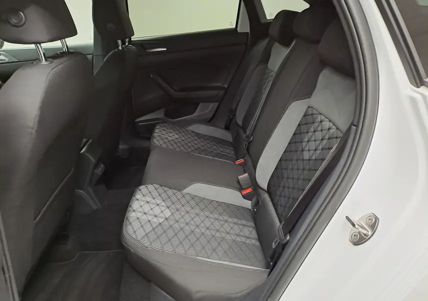 Vue intérieure côté droit des sièges arrière du Volkswagen Taigo 1.5 TSI 150 DSG7 R-Line Edition avec sellerie en tissu gris à motifs.