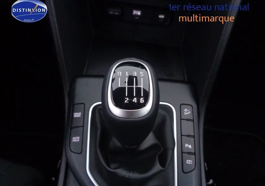 Gros plan sur le levier de vitesse manuel noir de la KIA SPORTAGE 1.6 T-GDI 2022, entouré de boutons de commande.
