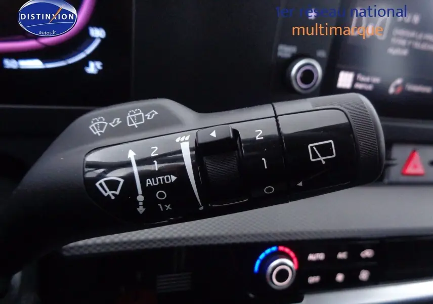 Gros plan sur la commande des essuie-glaces dans l’habitacle d’un KIA Sportage gris acier 2022, avec tableau de bord en arrière-plan.