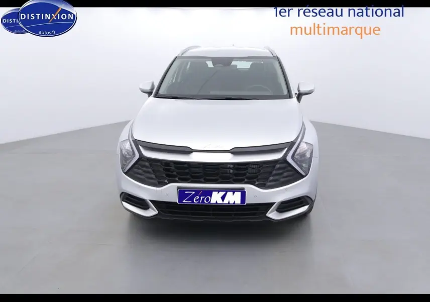 Vue frontale d'un KIA Sportage gris acier métal 2022 avec calandre noire et phares LED en forme de flèche.