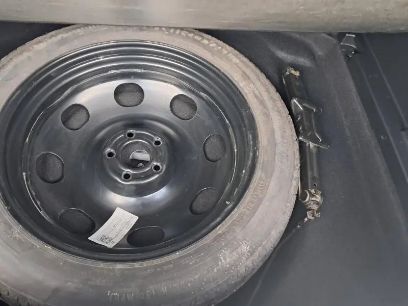 Roue de secours noire et cric dans le coffre d'une Citroën C5 Aircross blanc HDi 130 Shine 2019.