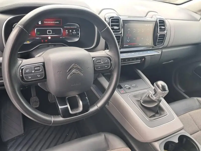 Intérieur du Citroën C5 Aircross blanc 2019, vue du poste de conduite avec volant multifonction et boîte manuelle.