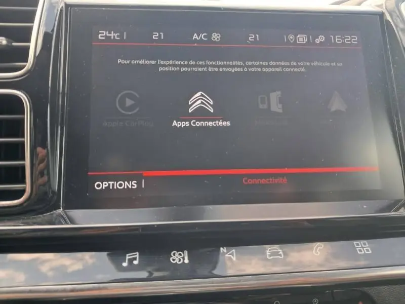 Écran tactile central du tableau de bord du Citroën C5 Aircross blanc, affichant les options de connectivité et la climatisation.