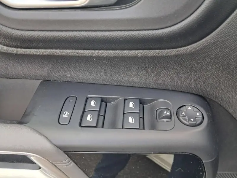 Vue rapprochée des commandes de lève-vitres et réglage des rétroviseurs côté conducteur du Citroën C5 Aircross blanc 2019.