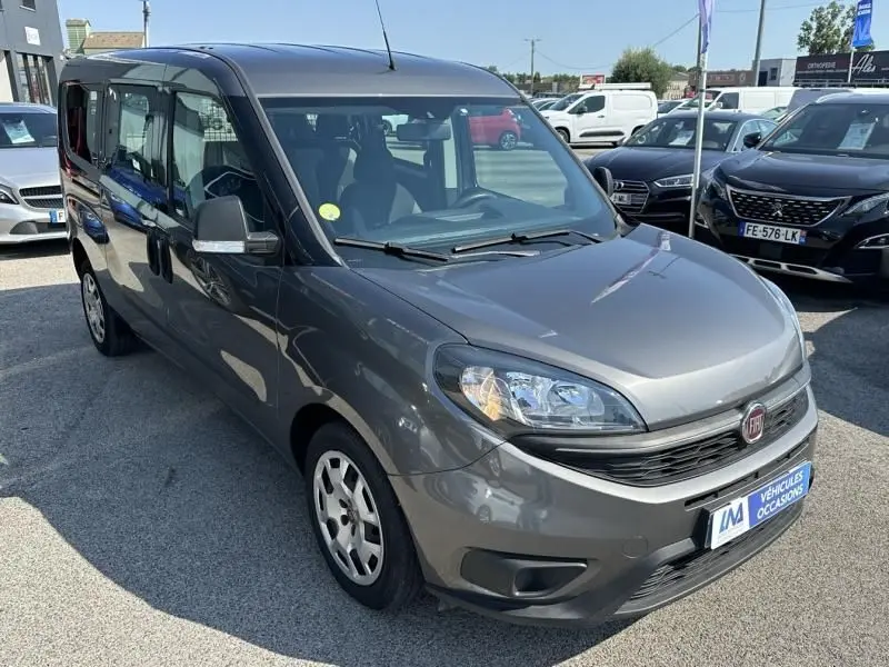 Fiat Doblo Cargo gris foncé vu en 3/4 avant droit sur un parking de véhicules d'occasion.