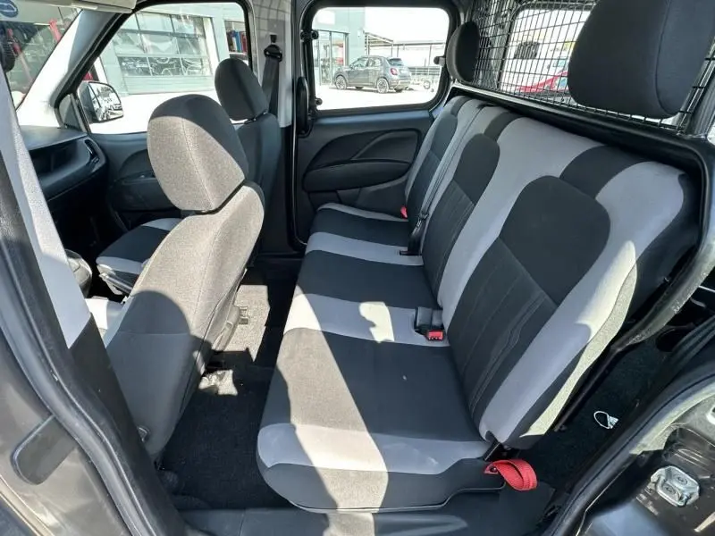 Vue intérieure côté droit du Fiat Doblo Cargo 2021 gris foncé, montrant la banquette arrière et la cloison métallique de séparation.