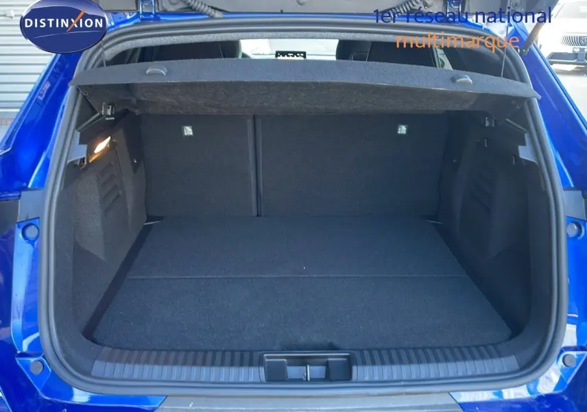 Coffre ouvert vu de l'arrière d'une Renault SYMBIOZ bleu iron metal, montrant l'espace de chargement vide.