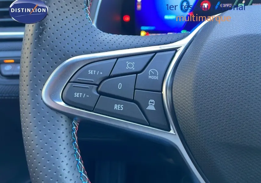 Gros plan sur les commandes au volant en cuir perforé avec surpiqûres bleu et rouge du Renault Symbioz bleu Iron Metal.