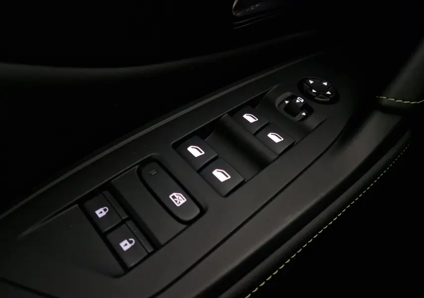 Gros plan sur les commandes de lève-vitres et rétroviseurs côté conducteur du Peugeot 308 blanc Okenite 2025.